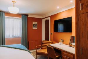 a hotel room with a bed and a desk and a tv at The Kings Arms Hotel in Keswick +57 photos