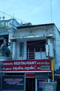 a building with a sign in front of it at Udhaya Lodge in Rāmeswaram
