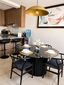 a dining room with a table and chairs and a kitchen at Casa de la Paz in Colima