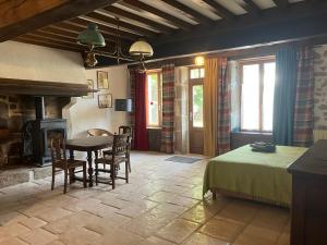a room with a table and a bed and a fireplace at Maison d'hôtes- éco tourisme in Moux-en-Morvan