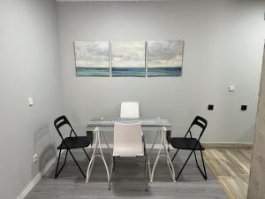 a dining room with a table and four chairs at A&R Santiago de Compostela in San Sebastián de los Reyes