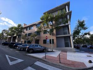 a building with cars parked on the side of a street at A&R Santiago de Compostela in San Sebastián de los Reyes