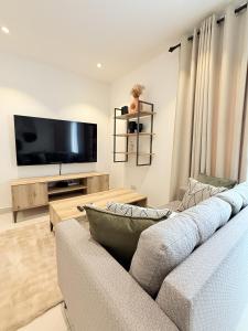 a living room with a couch and a flat screen tv at The Lennox D-Plus Apartments in Accra