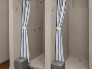 two blue curtains and two stools in a room at Moz Inn - Coconut View Resort in Lopes +73 photos