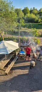 a group of people standing around a picnic table at Amsterdam Farm Lodge in Amsterdam