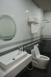 a bathroom with a sink and a toilet and a mirror at Viễn Dung Hotel in Buon Ma Thuot +23 photos