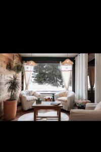 a living room with white couches and a table at Hôtel La Redoute in Les Rousses
