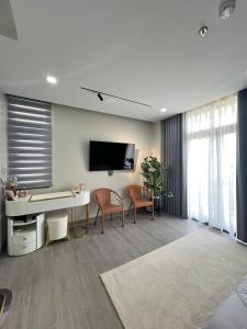 a living room with a desk and a tv on the wall at La Vida Residences Villa in Ấp Phước Thánh