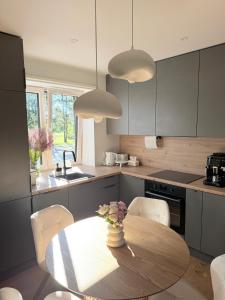 a kitchen with a table with a vase of flowers on it at Liiva apartement Kärdla in Kärdla