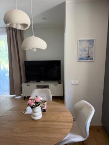 a living room with a table with a vase of flowers at Liiva apartement Kärdla in Kärdla +2 photos