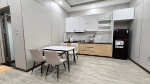 a kitchen with a table and chairs and a refrigerator at Viễn Dung Hotel in Buon Ma Thuot