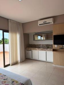 ein Wohnzimmer mit Fernseher und ein großes Zimmer in der Unterkunft Ventura Hotel in Barreiras