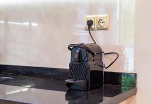 a black kettle sitting on a counter next to a lightswitch at Apartamento moderno en Tanger in Tangier