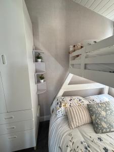 a small bedroom with a bed and a white cabinet at Retreat to the Chalet in Withernsea