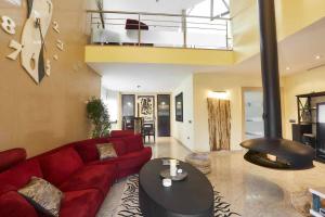 a living room with a red couch and a table at La Cantera Rural Spa in Viñaixa