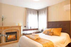 a bedroom with a bed with a fireplace at La Cantera Rural Spa in Viñaixa +42 photos