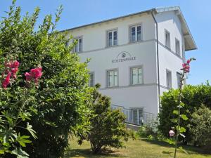 a white building with a sign on it at Villa Küstenperle, Meerblick-Appartements in Sassnitz