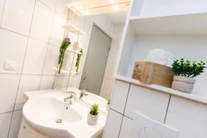 a white bathroom with a sink and a mirror at Nouveau - Le CityScape - Petite Venise in Colmar