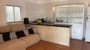 a living room with a couch and a kitchen at Casa completa com piscina 12min da praia in Porto Seguro
