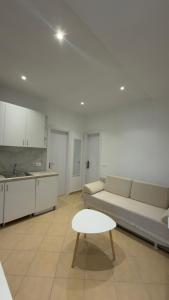 a living room with a couch and a table and a kitchen at Vila Gjoni in Sarandë