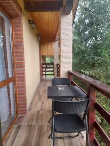 a balcony of a house with a table and chairs at Cabana Andrea in Arpaşu de Sus