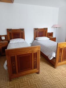 two beds in a room with wooden furniture at Appartamento Conti Schreck in Baselga di Pinè