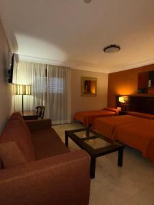 a hotel room with a couch and a bed at Hotel Sierra Hidalga in Ronda