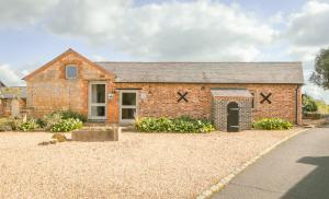 a brick house with a driveway in front of it at Tove Valley Cottages in Towcester