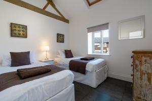 a bedroom with two beds and a window at Tove Valley Cottages in Towcester