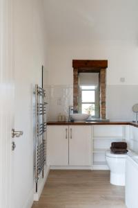 a white bathroom with a sink and a toilet at Tove Valley Cottages in Towcester +147 photos