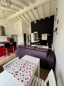 a living room with a purple couch and a table at La Casita cerca de la playa in Santander +11 photos