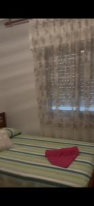 a red napkin sitting on a bed with a window at Argentina 32 in Ayora +2 photos