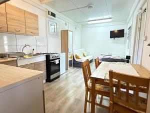 a kitchen and dining room with a table and chairs at Domek u Franka in Smołdzino