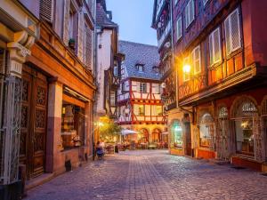 an empty street in an old town at night at Nouveau - Le CityScape - Petite Venise in Colmar