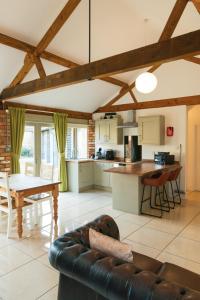 a kitchen and living room with a couch and a table at Tove Valley Cottages in Towcester