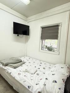 a bedroom with a bed and a flat screen tv at Domek u Franka in Smołdzino