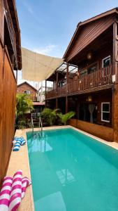 a swimming pool in front of a house at Hotelito Villas Holbox - Self Check In in Holbox Island