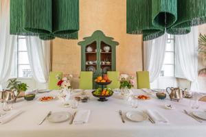 a table with a white table cloth and green curtains at Palazzo Venneri Lloyd - Historic Heritage Palazzo in Gallipoli