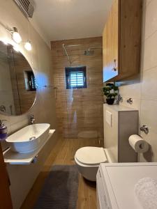 a bathroom with a sink and a toilet and a mirror at Apartment Roko (10m from the beach) in Pašman +39 photos