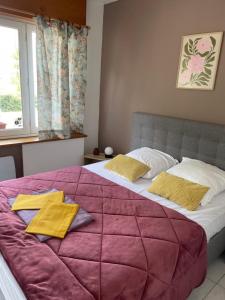 a bedroom with a large bed with a purple blanket at La dame du bois in Gramat