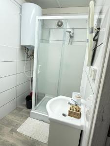 a white bathroom with a shower and a sink at Domek u Franka in Smołdzino +14 photos