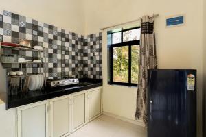 a kitchen with a black refrigerator and a window at StoneHaven 1BHK pvt Pool in Agashi