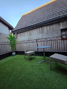 a patio with two benches and a table and a fence at L'Ecrin Vert & Spa in Kaysersberg