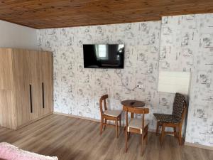 a dining room with a table and a tv on a wall at Monteurhaus Salzwedel in Salzwedel