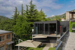 a modern house with a balcony with umbrellas at Lake side Dilijan in Dilijan