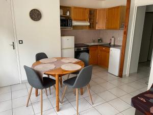 a kitchen with a wooden table and chairs in a kitchen at La dame du bois in Gramat +4 photos