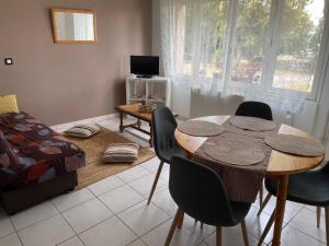 a living room with a table and chairs and a bed at La dame du bois in Gramat