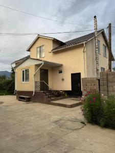 aige house with a porch and a driveway at Ademi Guest House in Kochkorka