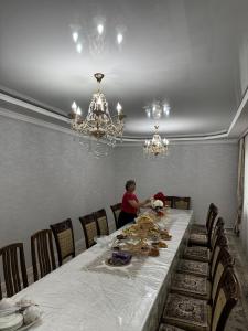 a woman sitting at a table in a dining room at Ademi Guest House in Kochkorka +20 photos