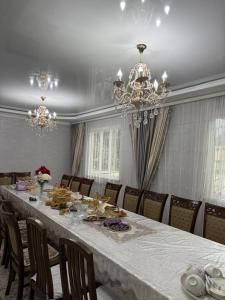 a large dining room with a long table and chandelier at Ademi Guest House in Kochkorka